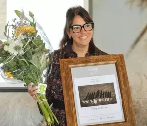 Foto van Fabienne die de beste bruidsfoto van het jaar award in handen neemt