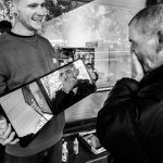 Kapper toont een man zijn nieuwe kapsel in een spiegel, waarbij de man emotioneel reageert; documentaire foto door Isabelle Hattink voor De Straatkapper.